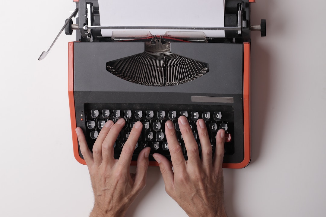 courriel contenu - mains sur une machine à écrire rouge - Photo par Andrea Piacquadio - Pexels