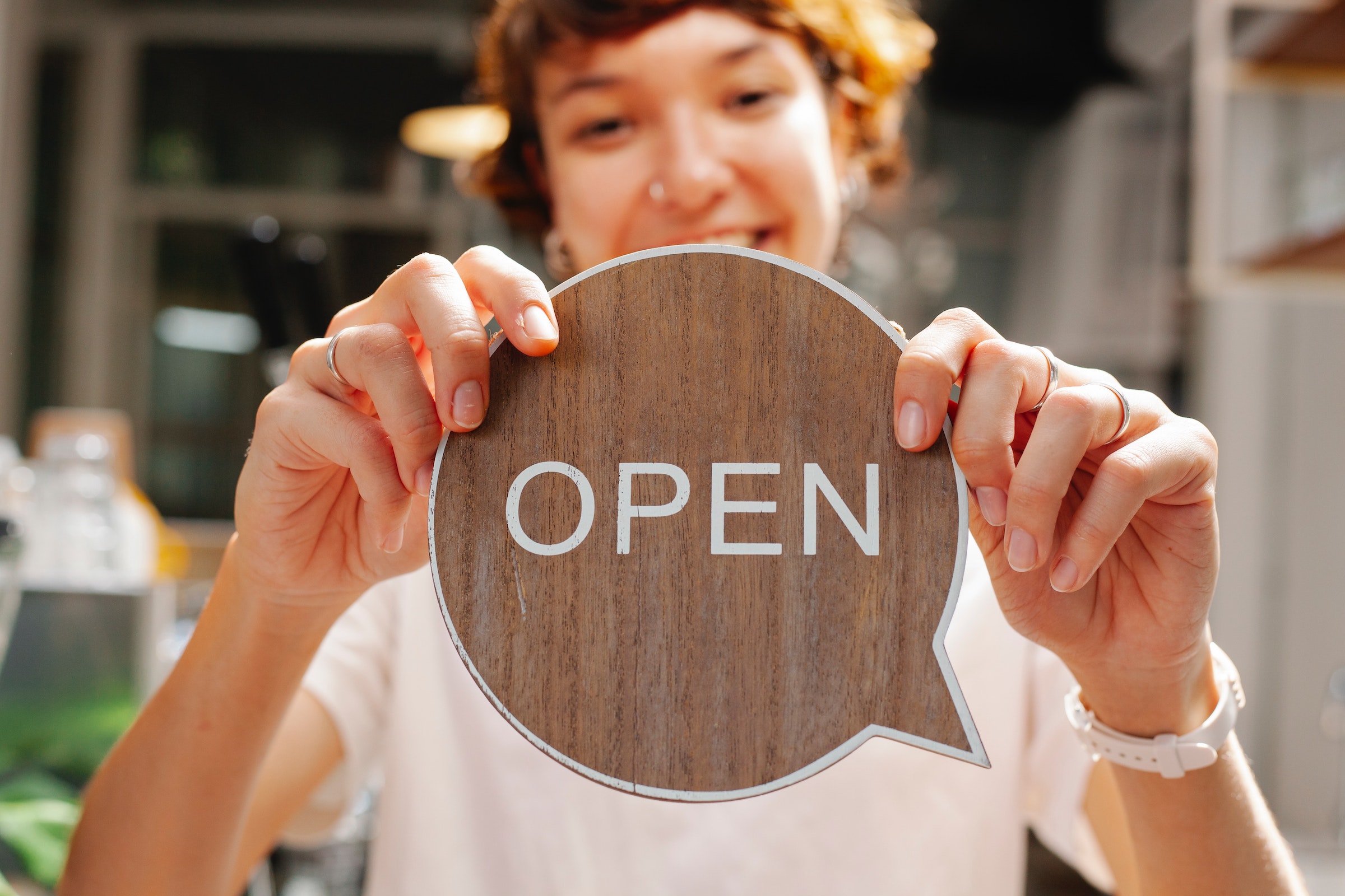 pré-en-tête - dame avec un panneau Open en bois