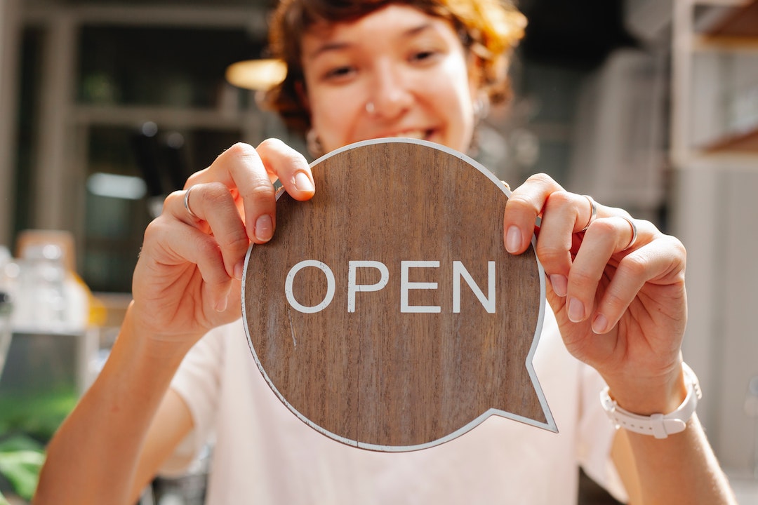 pré-en-tête - dame avec un panneau Open en bois