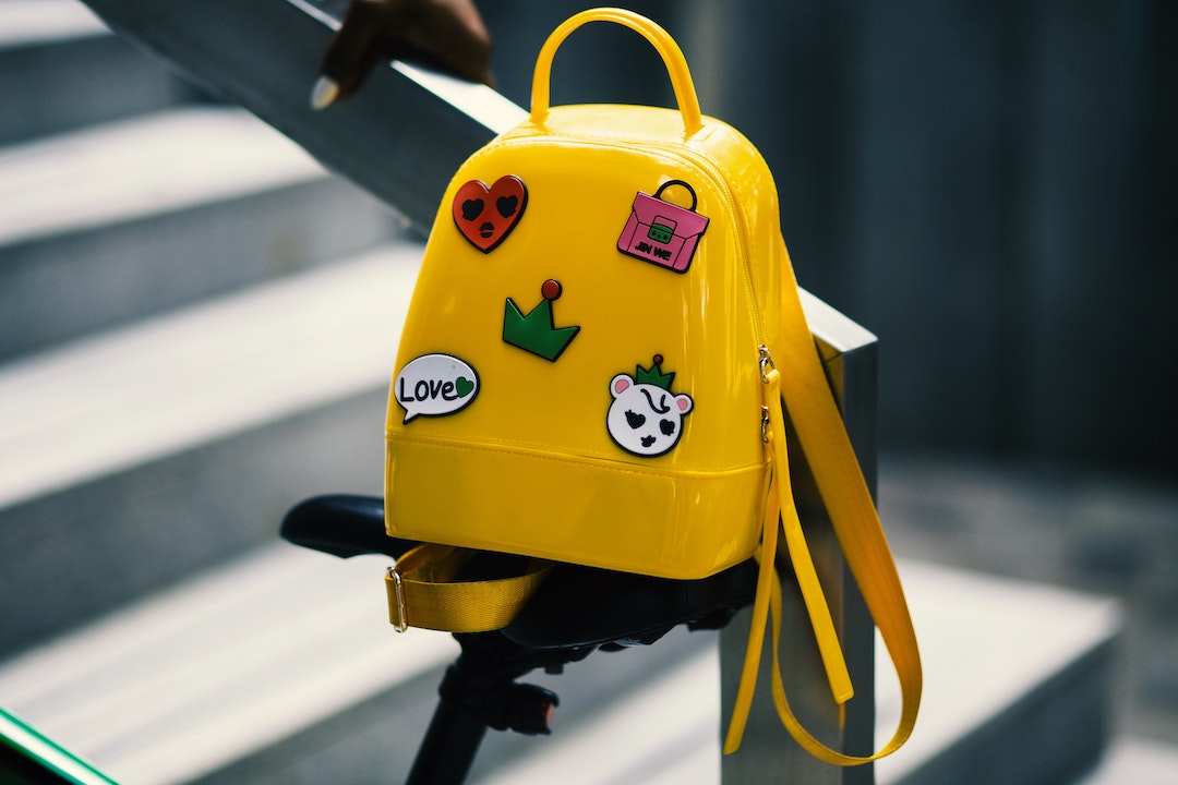 Cartable jaune suspendu à une rampe d'escalier